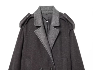 Detailed macro view of dark grey wool blend double-breasted coat buttons and shoulder epaulets