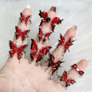 Detail of red and black enamel butterfly rings with silver finish on white faux fur