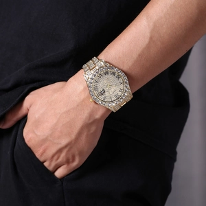Close-up of luxury gold quartz watch with full rhinestones and Roman numerals on wrist