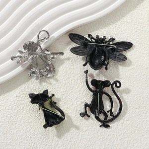 Detail view of the metal back and pin fasteners for cat, bee, and violin brooches