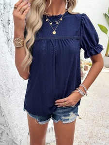 Detail shot of navy blue short sleeve top featuring intricate lace hollow-out fabric design