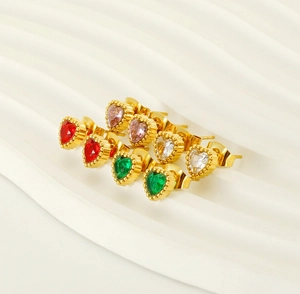 Close-up of heart-shaped zircon earrings in red, pink, green, and white with gold bead borders
