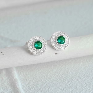 Macro detail of silver S925 round emerald cat-eye studs with halo crystal stones