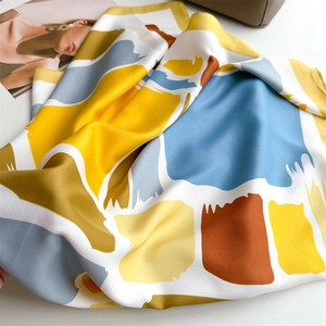 Detailed view of abstract geometric printed silk scarf with smooth satin texture