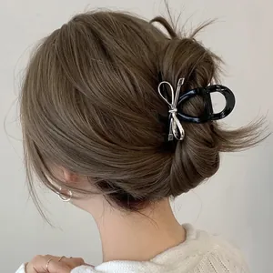 Silver bow metal hair claw clip for elegant updo hairstyles on brown hair