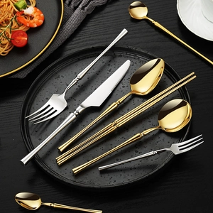 Polished 304 stainless steel cutlery set with gold and silver finish on a dark platter