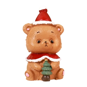 Cute Christmas bear figurine wearing red hat and cloak holding a small Xmas tree