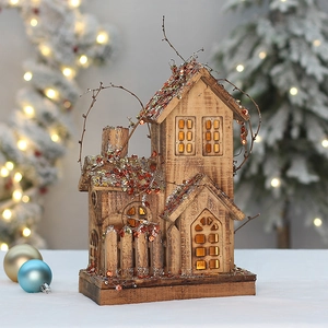 Close-up of lighted wooden Christmas house with warm LED glow and festive glitter detail