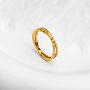 Detailopname van gouden kruisring met sprankelende strass steentjes en luxe uitstraling