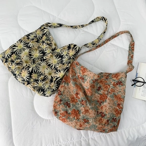 Detailed view of floral canvas tote bags with daisy patterns and soft cotton texture