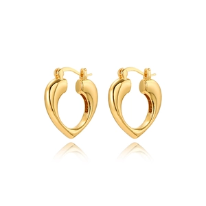 Detailed macro view of heart shaped golden 18k earrings with a polished mirror finish