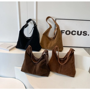 Detailed close-up of suede tote bags in four neutral tones with leather straps