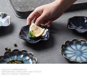 Close-up of petal-shaped ceramic dipping sauce dishes with blue kiln-glaze finish