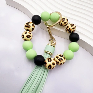 Detail of leopard print wood beads and mint green silicone beads on a ring keychain