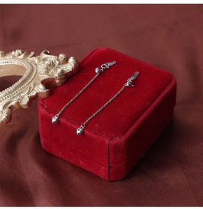 Detailed macro view of S925 sterling silver heart-shaped pendant on long chain earrings