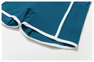 Détails du short de yoga bleu canard avec passepoil blanc et poches latérales utiles