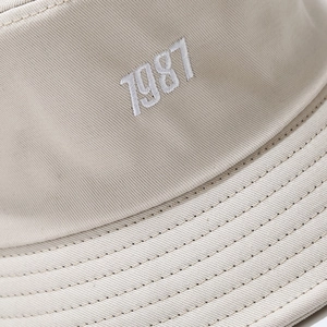 Beige cotton bucket hat with white 7987 embroidery and reinforced stitched brim