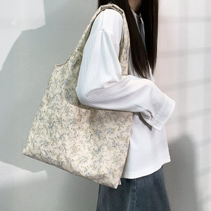 Floral canvas tote bag with vintage oil painting print shown on a model's shoulder
