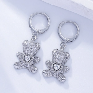 Detailed view of silver bear earrings with heart-shaped stone and cubic zirconia inlay