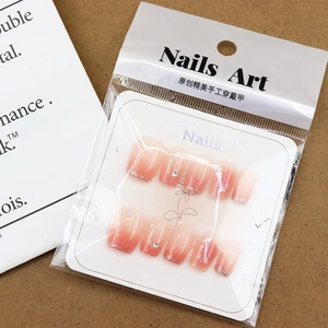 Faux ongles faits main dégradé rose avec paillettes argentées, strass et perles