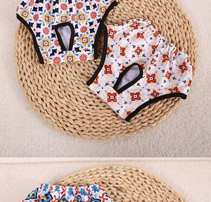 Detail of floral dog sanitary pants showing elastic waistband and tail hole on straw mat