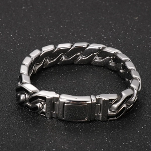 Macro detail of silver stainless steel Cuban link bracelet with black stripe punk accents