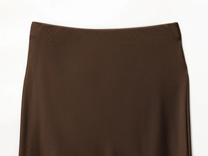 Detailed view of dark brown satin fabric texture and waistline on a midi skirt