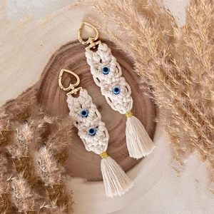 Detail of bohemian handmade cotton keychain with evil eye beads and golden heart clasp