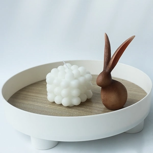 Ensemble bougie bulle blanche et figurine lapin marron sur plateau rond en bois
