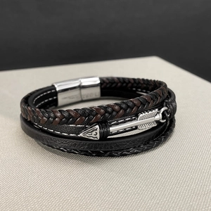 Detail of multi-layer braided leather bracelet with silver arrow pendant and magnetic clasp