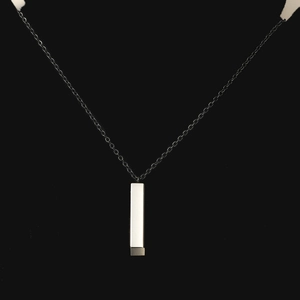 Gros plan d'un collier pendentif cuboïde géométrique minimaliste en acier poli