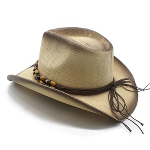 Detail of straw cowboy hat featuring burnt-edge effect and beaded leather tassel