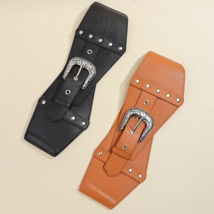 Close-up of vintage elastic wide belts with ornate silver floral buckles and metal rivets