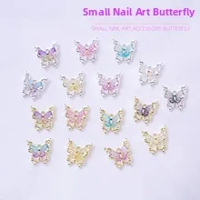 Macro view of small resin butterfly nail charms with gold and silver metal borders