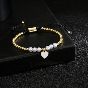 Détail du bracelet cœur ajustable avec perles dorées, nacre et cordon tressé noir