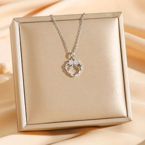 Collier nœud en titane argenté avec zircons brillants sur fond en soie luxueux