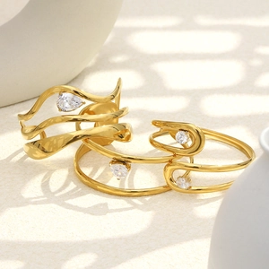 18K gold plated stainless steel bangles with water drop zirconia on modern sand background