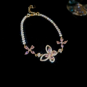 Detail of cherry blossom pink zircon butterfly flower bracelet with polished gold finish