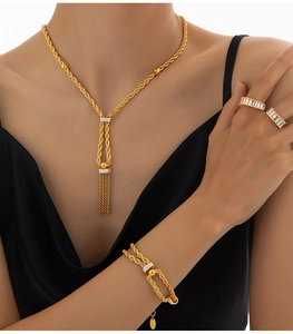 Détails d'un ensemble de bijoux dorés avec chaînes torsadées et cristaux pavés étincelants