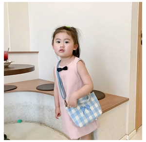 Close-up of kids blue plaid canvas crossbody bag with a cute 3D bow on a child model