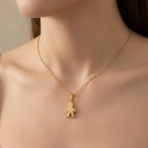 Close-up of golden boy pendant necklace on neck, minimalist stainless steel jewelry