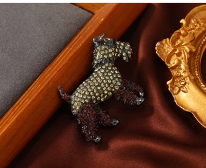 Detail of a vintage dog brooch featuring sparkling red and yellow crystal pavé settings