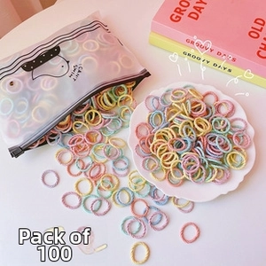 Detail of 100 colorful macaron hair ties set in a translucent bird-print zipper pouch