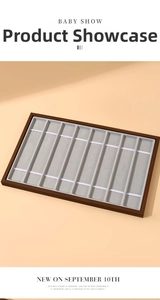Macro view of a walnut grain 10-slot watch display tray with soft velvet lining