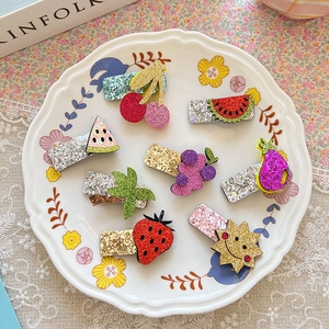 Close-up of 8pcs glitter fruit hair clips set in a white ceramic dish