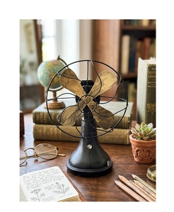 Detail of vintage metal desk fan ornament with aged finish in a retro study scene