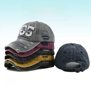 Detailed close-up of distressed washed cotton baseball caps with 1985 embroidery details
