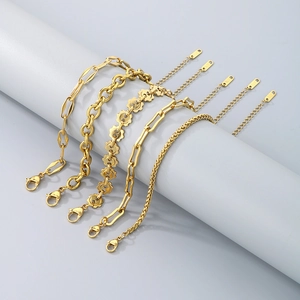 Close-up of five 18K gold plated stainless steel Cuban bracelets with extension chains