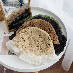 Detail of woven straw hats featuring lace ruffles and hollowed-out crochet patterns