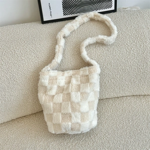 Close-up of a plush checkerboard shoulder bag in soft cream and beige faux fur texture